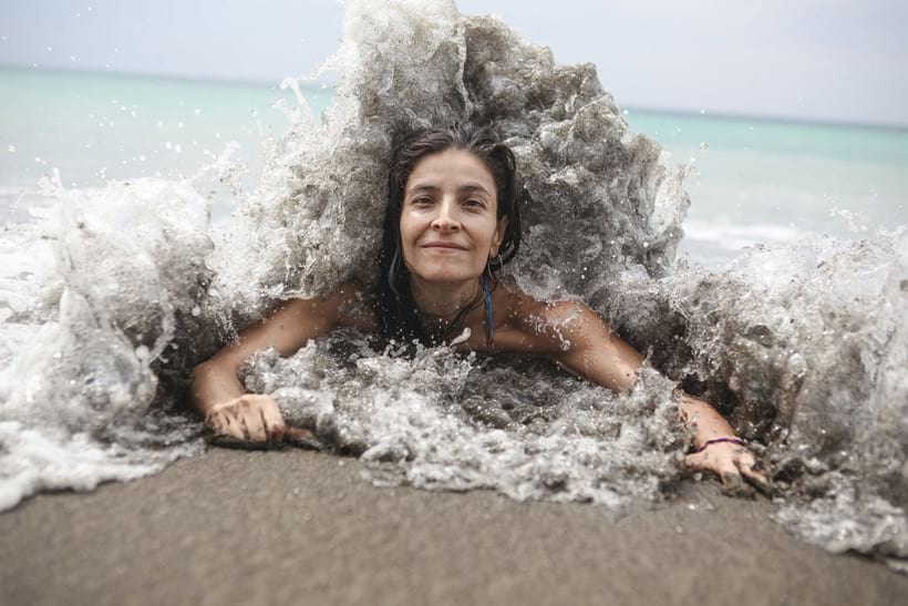 Девушку вот-вот накроет океанской волной на пляже побережья Чоко, Колумбия