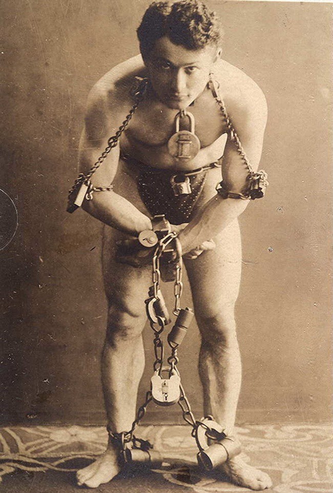 Фокусник Гарри Гудини позирует в цепях, 1899.