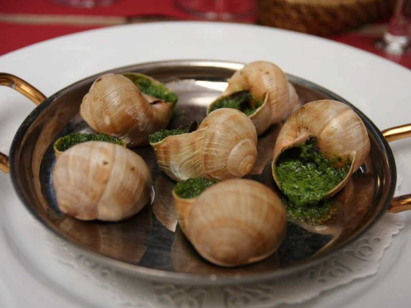 Эскарго — улитки — кажется странным блюдом для иностранцев, но во Франции считается деликатесом. Улитки подаются горячими в раковинах с чесноком и маслом.