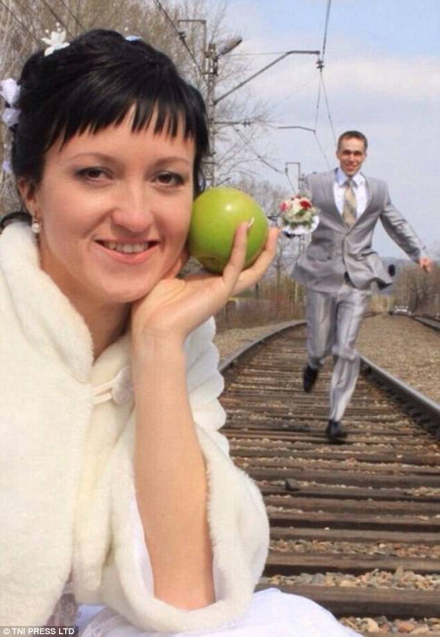  Невеста позирует с яблоком, жених бежит по рельсам. Почему бы и нет.