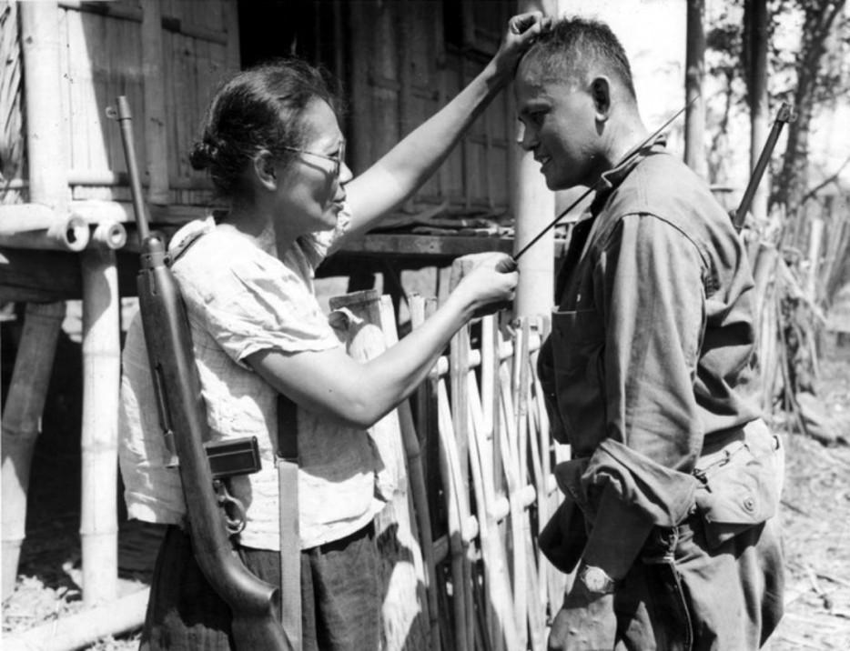 26. Филиппинская партизанка Нивес Фернандес показывает американскому солдату, как она убивала японских солдат во время оккупации. 1944 год.