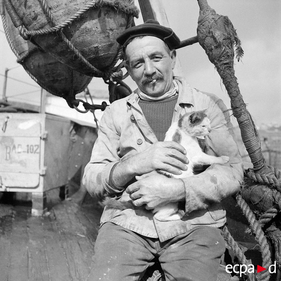Траулер в море с матросом с кошкой на руках, 1939 года.